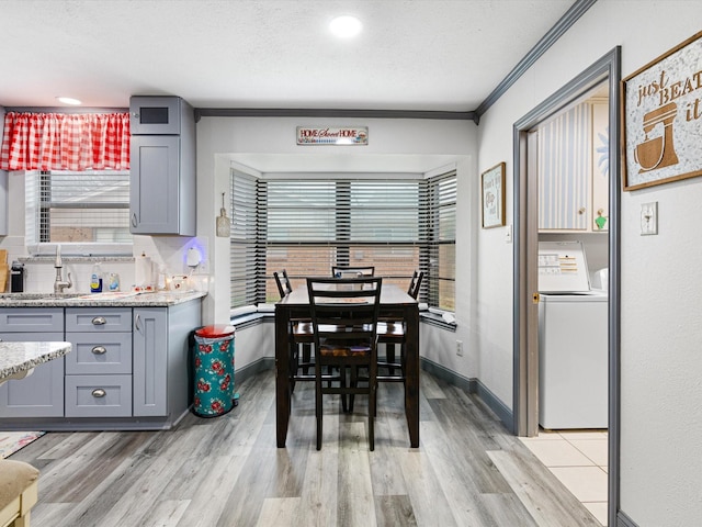 dining space with washer / clothes dryer, sink, a wealth of natural light, and light wood-type flooring