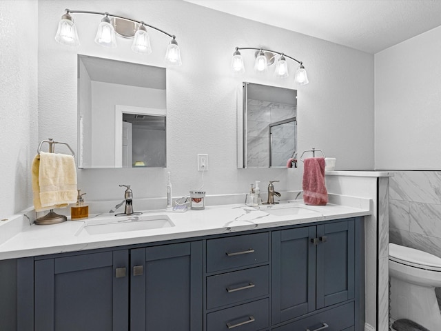 bathroom featuring vanity, tile walls, toilet, and a shower