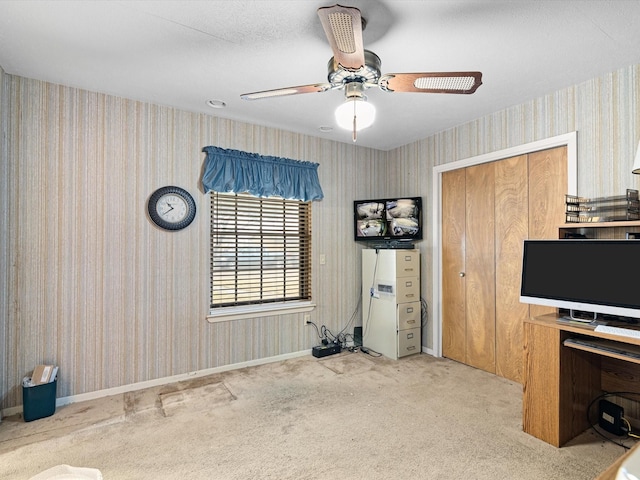 unfurnished office with ceiling fan and light colored carpet