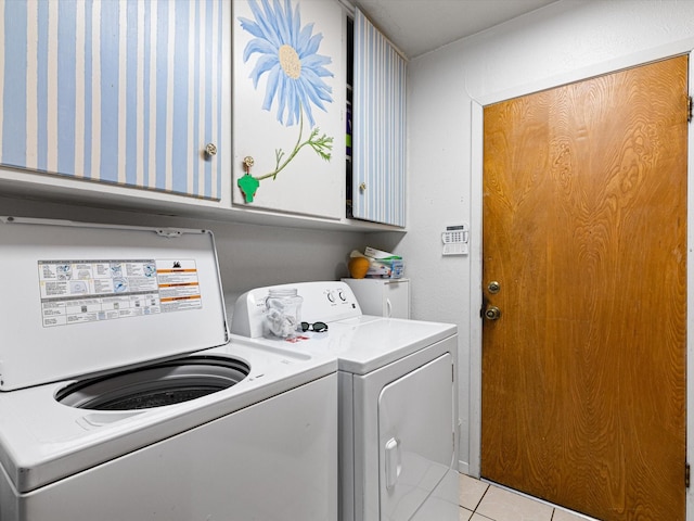 laundry area featuring light tile patterned flooring, cabinets, and separate washer and dryer