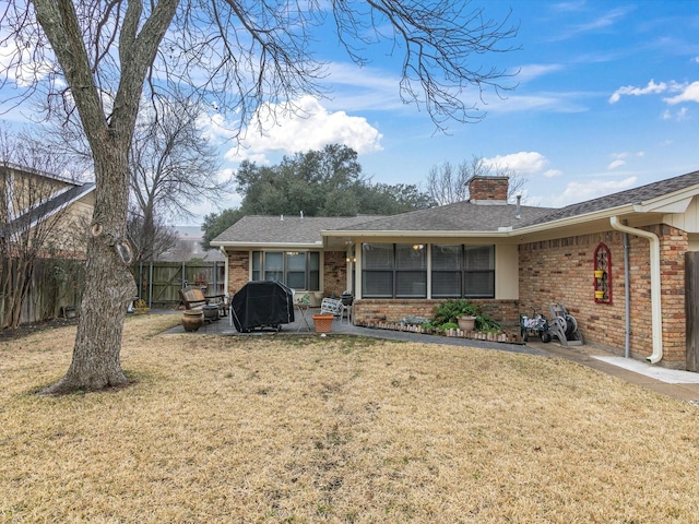 back of property with a patio area and a lawn