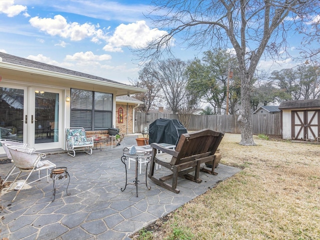 view of patio with a storage unit and a grill