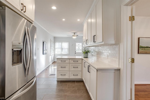 kitchen with white cabinetry, stainless steel fridge, kitchen peninsula, and tasteful backsplash