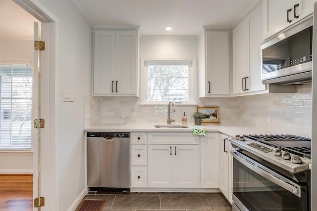 kitchen featuring white cabinetry, appliances with stainless steel finishes, sink, and ornamental molding