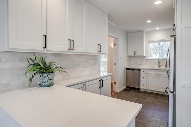 kitchen with sink, crown molding, stainless steel appliances, tasteful backsplash, and white cabinets