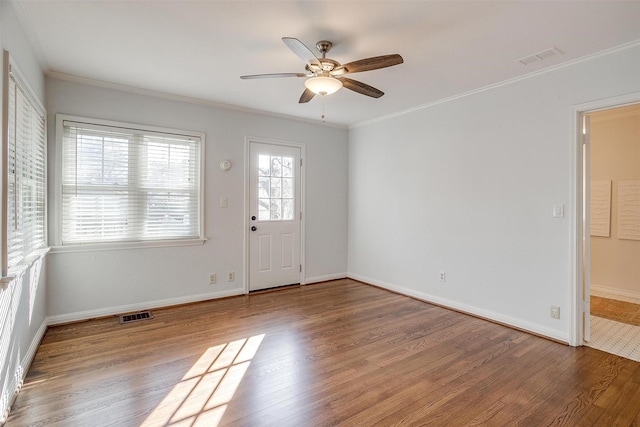 foyer entrance with hardwood / wood-style flooring, ornamental molding, and ceiling fan