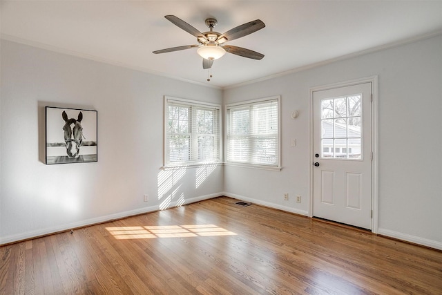 foyer featuring crown molding, ceiling fan, and wood-type flooring