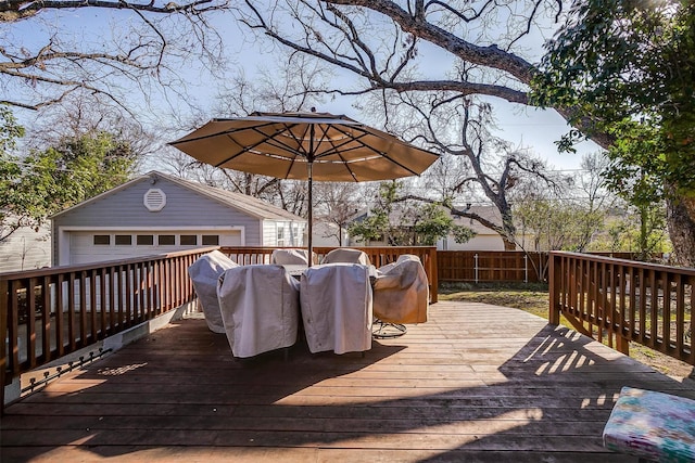 wooden deck with a garage and an outdoor structure