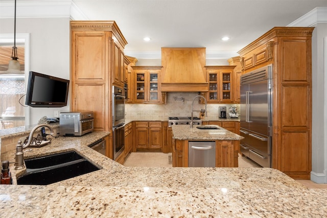 kitchen featuring pendant lighting, sink, appliances with stainless steel finishes, a kitchen island with sink, and custom exhaust hood