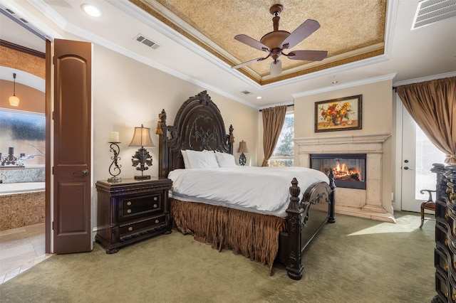 carpeted bedroom featuring ceiling fan, ornamental molding, a premium fireplace, and a raised ceiling