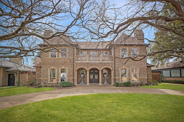 view of front facade featuring a front yard and a balcony