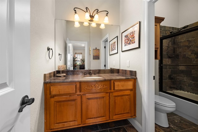 full bathroom with toilet, vanity, and bath / shower combo with glass door