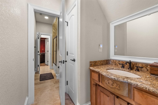 bathroom with vanity, tile patterned floors, and lofted ceiling