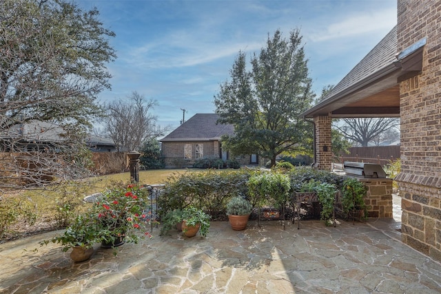 view of patio with area for grilling and a grill