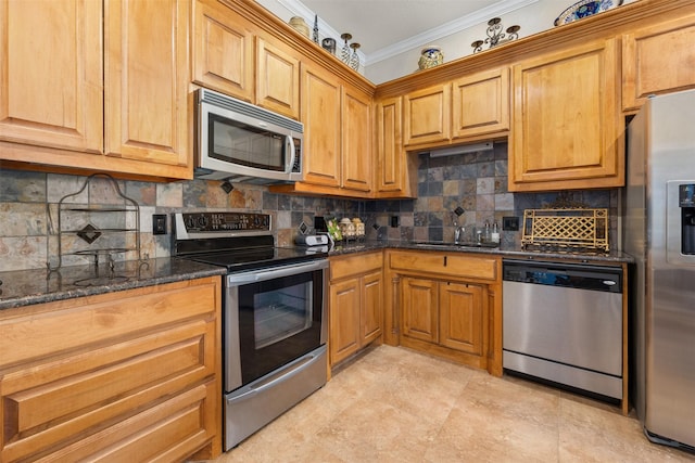 kitchen featuring sink, dark stone countertops, ornamental molding, appliances with stainless steel finishes, and decorative backsplash