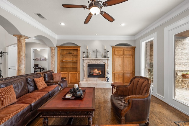 living room with ornate columns, crown molding, hardwood / wood-style flooring, and a fireplace