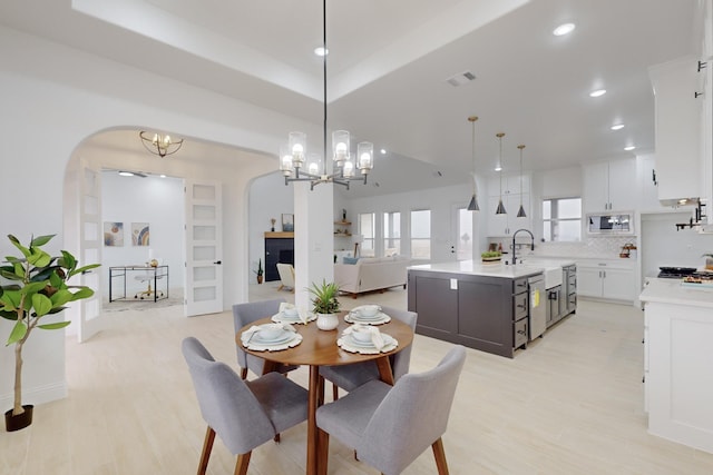 dining area with sink, a chandelier, and light hardwood / wood-style floors