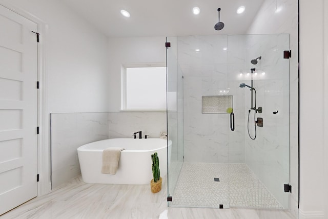 bathroom featuring tile walls and shower with separate bathtub