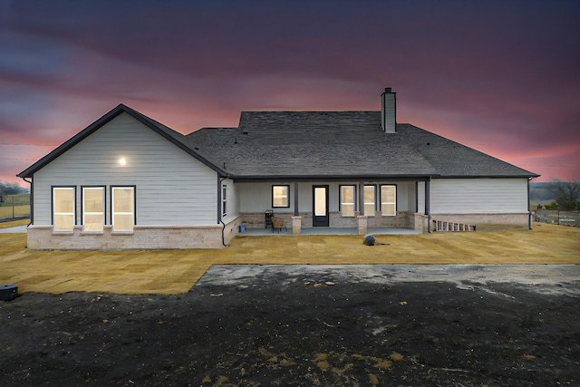 back house at dusk with a patio