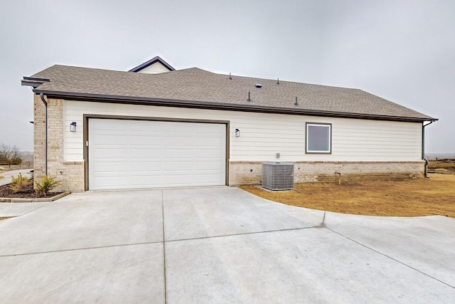 view of property exterior with a garage and central AC unit