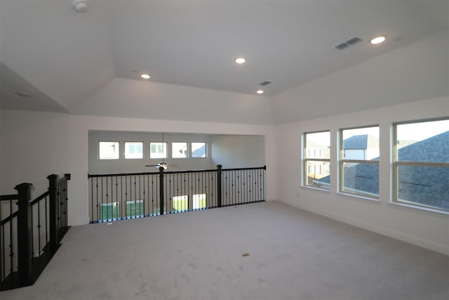 unfurnished room with lofted ceiling, a wealth of natural light, carpet, and ceiling fan