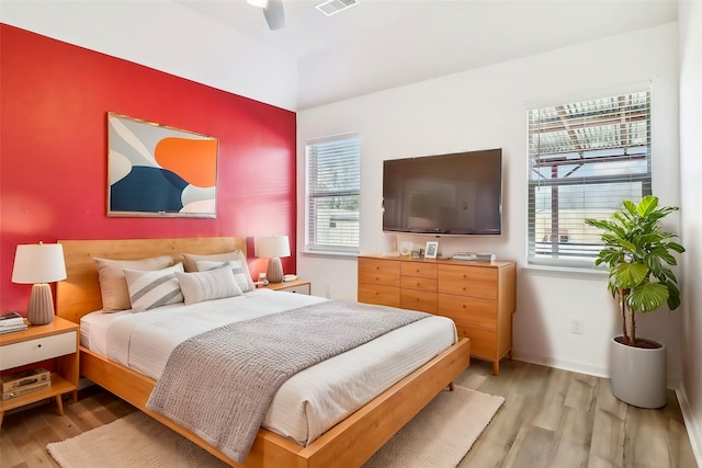 bedroom featuring multiple windows, light hardwood / wood-style flooring, and ceiling fan