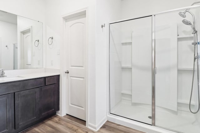 bathroom with walk in shower, wood-type flooring, and vanity