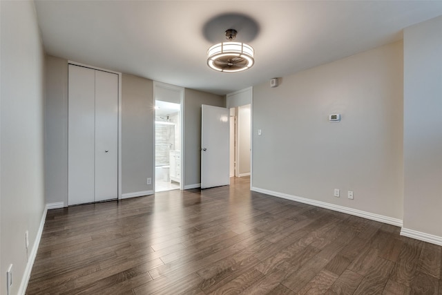 unfurnished bedroom featuring dark wood-type flooring and connected bathroom