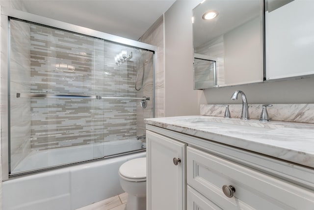 full bathroom featuring vanity, enclosed tub / shower combo, and toilet