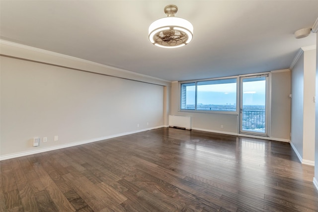 empty room with ornamental molding, dark hardwood / wood-style floors, and radiator