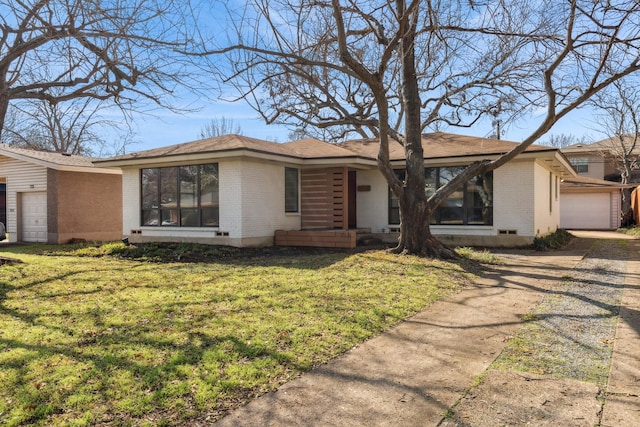 ranch-style house featuring a garage and a front lawn