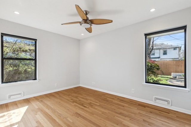 unfurnished room with ceiling fan, a healthy amount of sunlight, and light hardwood / wood-style floors