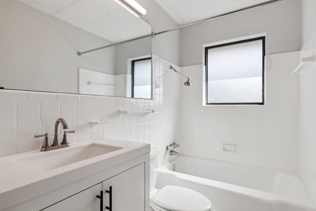 full bathroom featuring vanity, toilet, tiled shower / bath combo, and a wealth of natural light