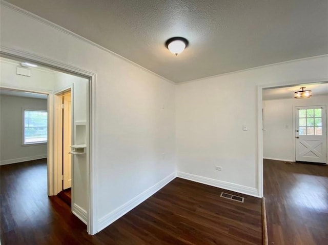 unfurnished room with dark hardwood / wood-style flooring and a textured ceiling