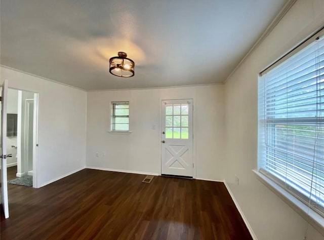 spare room featuring crown molding and dark hardwood / wood-style floors