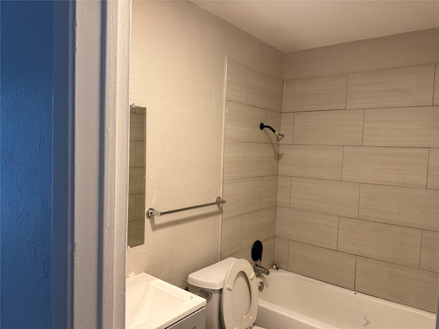 full bathroom with tiled shower / bath combo, vanity, and toilet