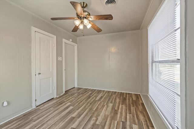 spare room with hardwood / wood-style floors, ornamental molding, and ceiling fan