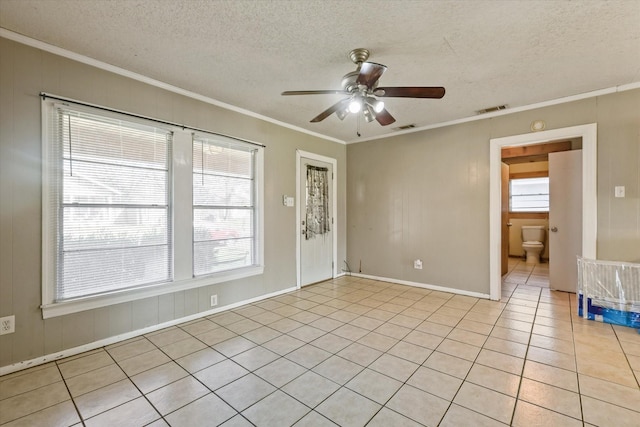 tiled empty room with crown molding, ceiling fan, and a textured ceiling