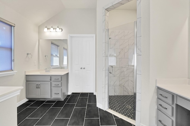 bathroom featuring tile patterned floors, lofted ceiling, a shower with shower door, and vanity