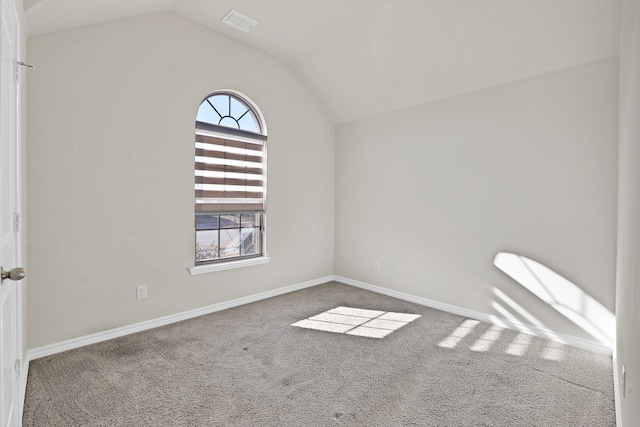 carpeted empty room featuring lofted ceiling