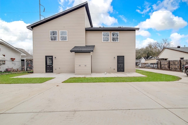 rear view of house featuring a yard and a patio area