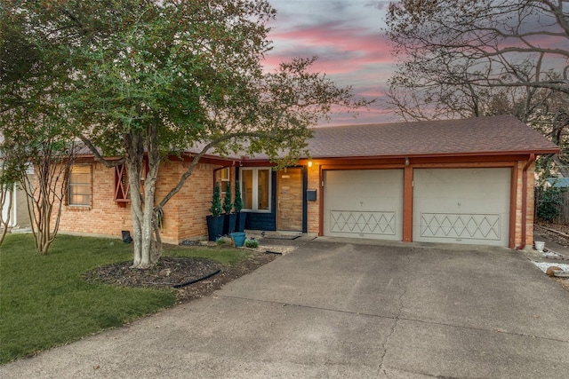 single story home with a garage and a yard