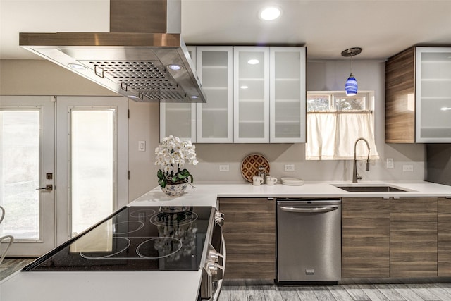 kitchen featuring pendant lighting, sink, stainless steel appliances, island exhaust hood, and french doors