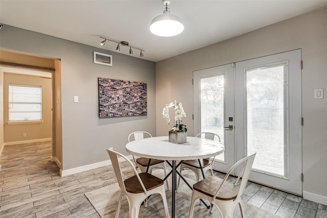 dining area with track lighting and french doors