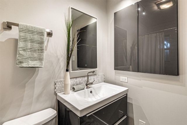 bathroom with vanity, toilet, and decorative backsplash