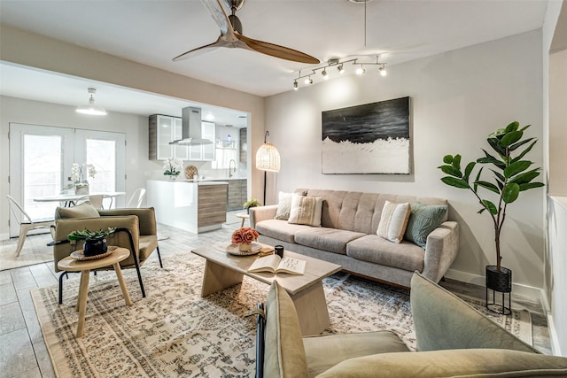 living room with sink, ceiling fan, and light wood-type flooring