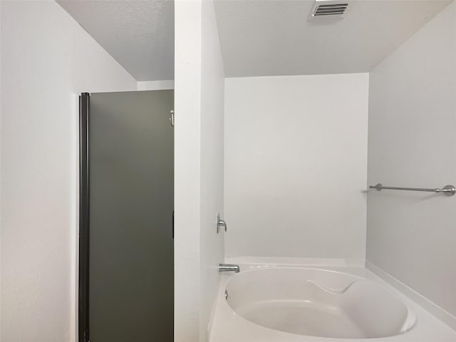 bathroom featuring a bathtub and a textured ceiling