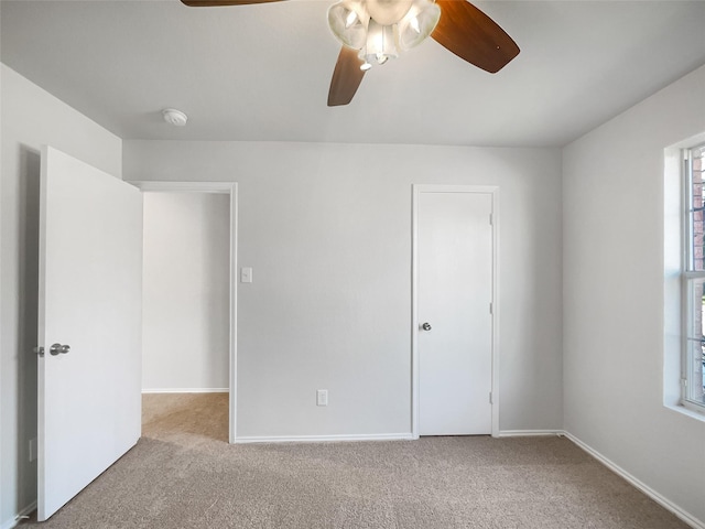 unfurnished bedroom featuring light carpet and ceiling fan