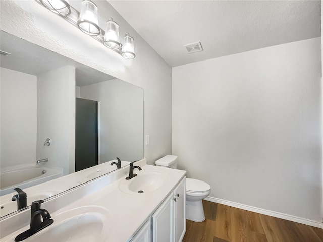 full bathroom with shower / tub combination, vanity, hardwood / wood-style floors, and toilet