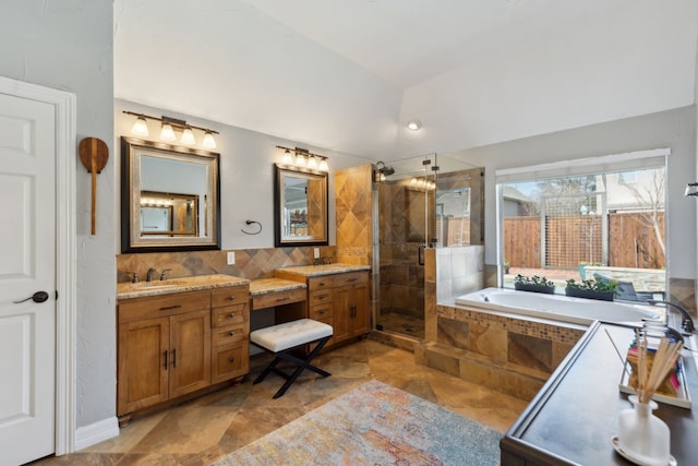 bathroom featuring lofted ceiling, vanity, decorative backsplash, and shower with separate bathtub